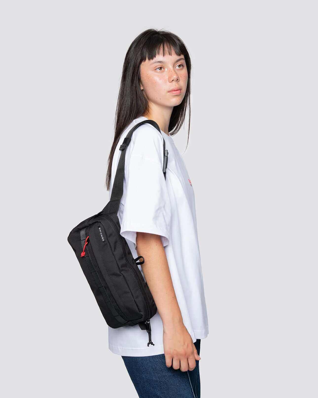 Model trägt eine schwarze crossbody reisetasche, ideal für Reisen und tägliche Verwendung.