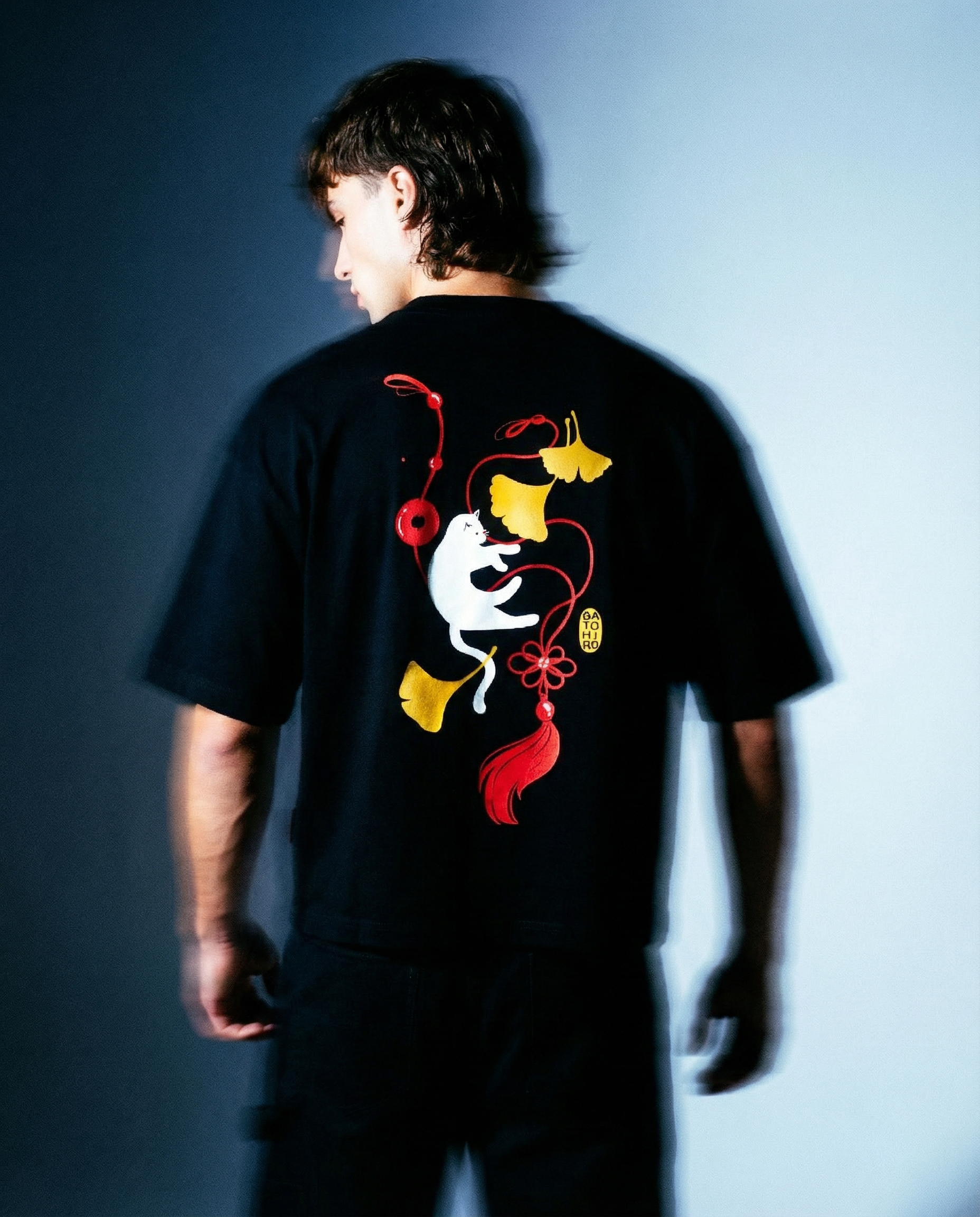 Muž nosící Ginko Cat Tee - Black Cropped Oversized s grafikou kočky a ginkgo na zadní straně, Premium Oversized tričko z česka.