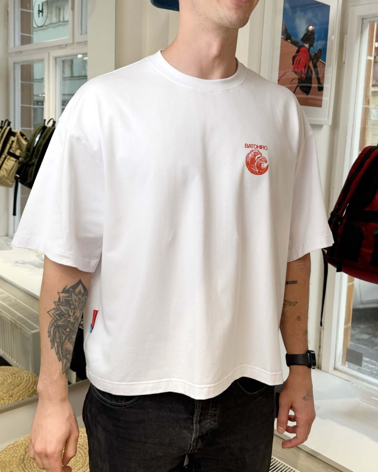 Model wearing Hiro Wave cropped oversized tee, featuring unique design and comfortable fit, in a stylish shop setting.